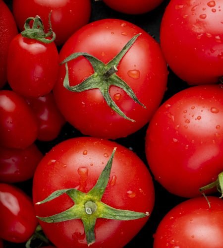 top view of ripe fresh tomatoes with water drops on black background